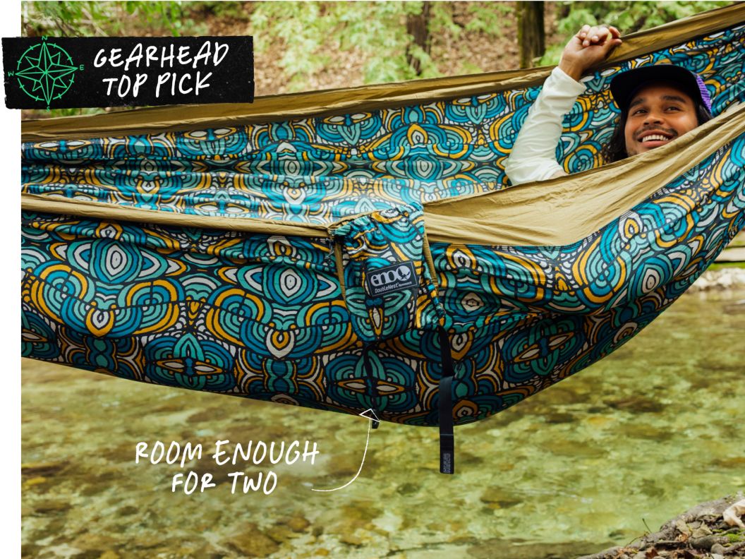 A smiling person lounges in a wildly-printed hammock. Text overlay reads: Gearhead top pick, room enough for two.